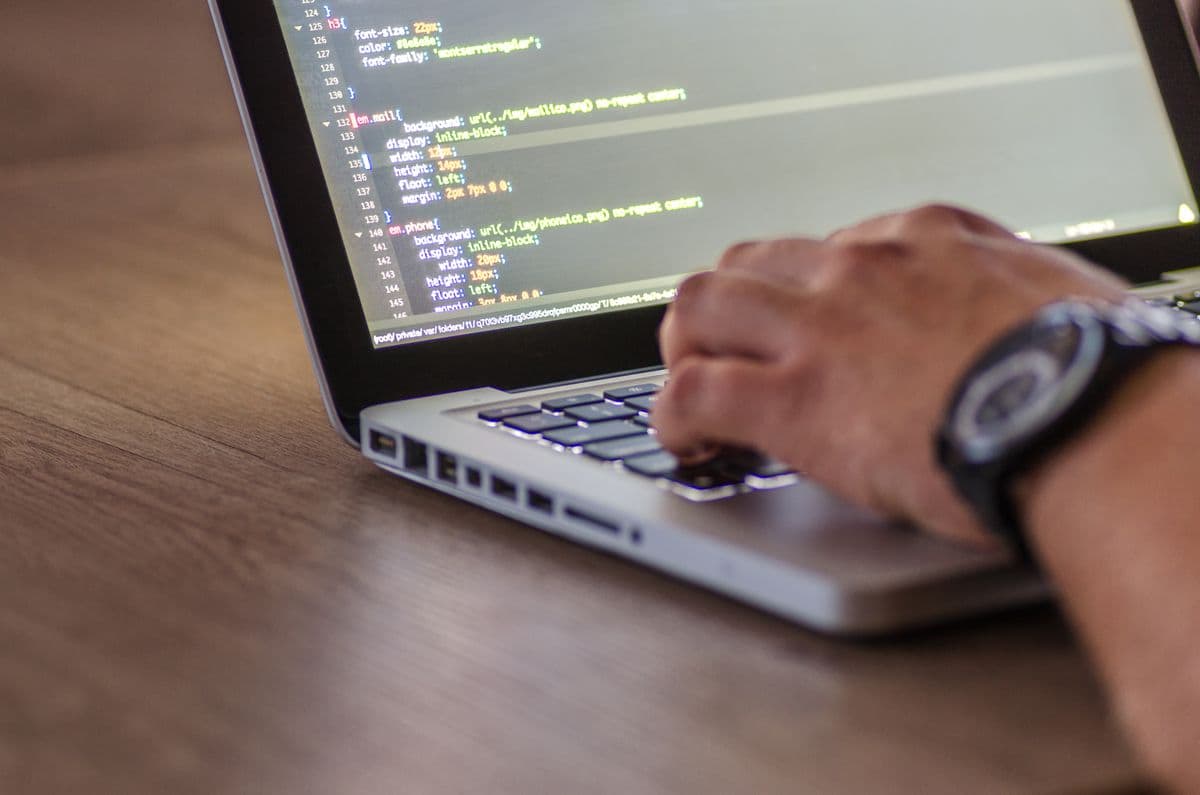 Developer typing theme code on a laptop